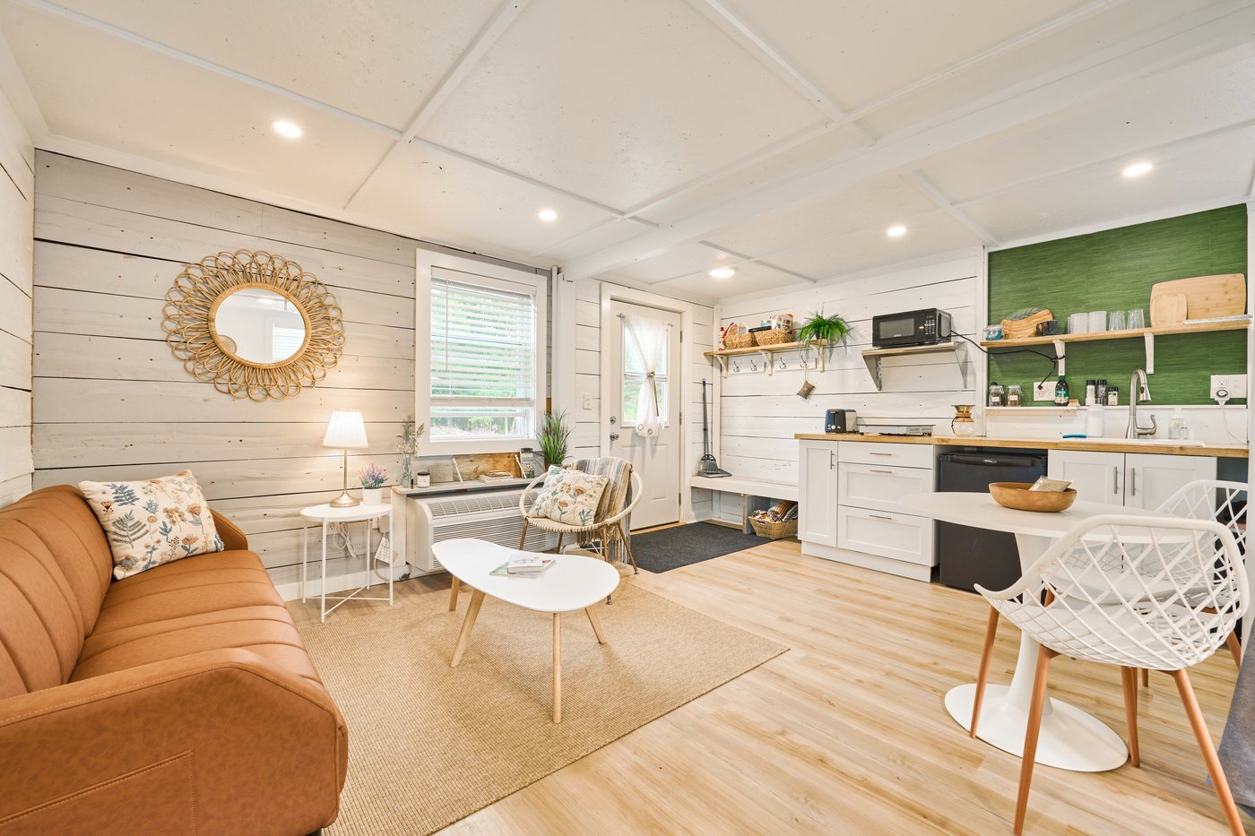 Living room with shiplap walls and a tan sofa